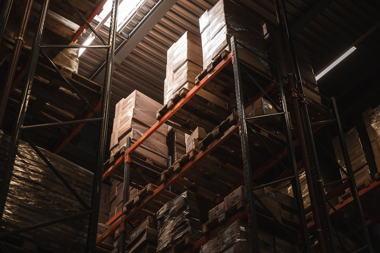 journey Interior view of a warehouse with stacked cardboard boxes on high shelves, showcasing storage and logistics.